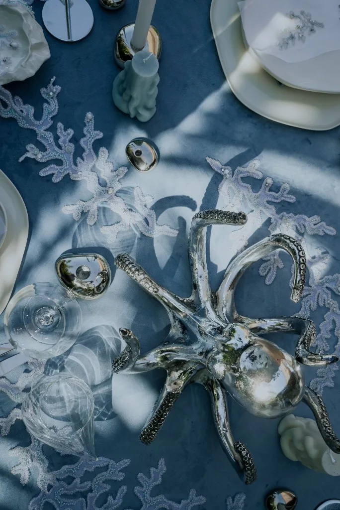 Welcome dinner tablescape at Sakhalin Dubai with silver octopus centerpiece, coral details and dusty blue linens in a refined seaside theme